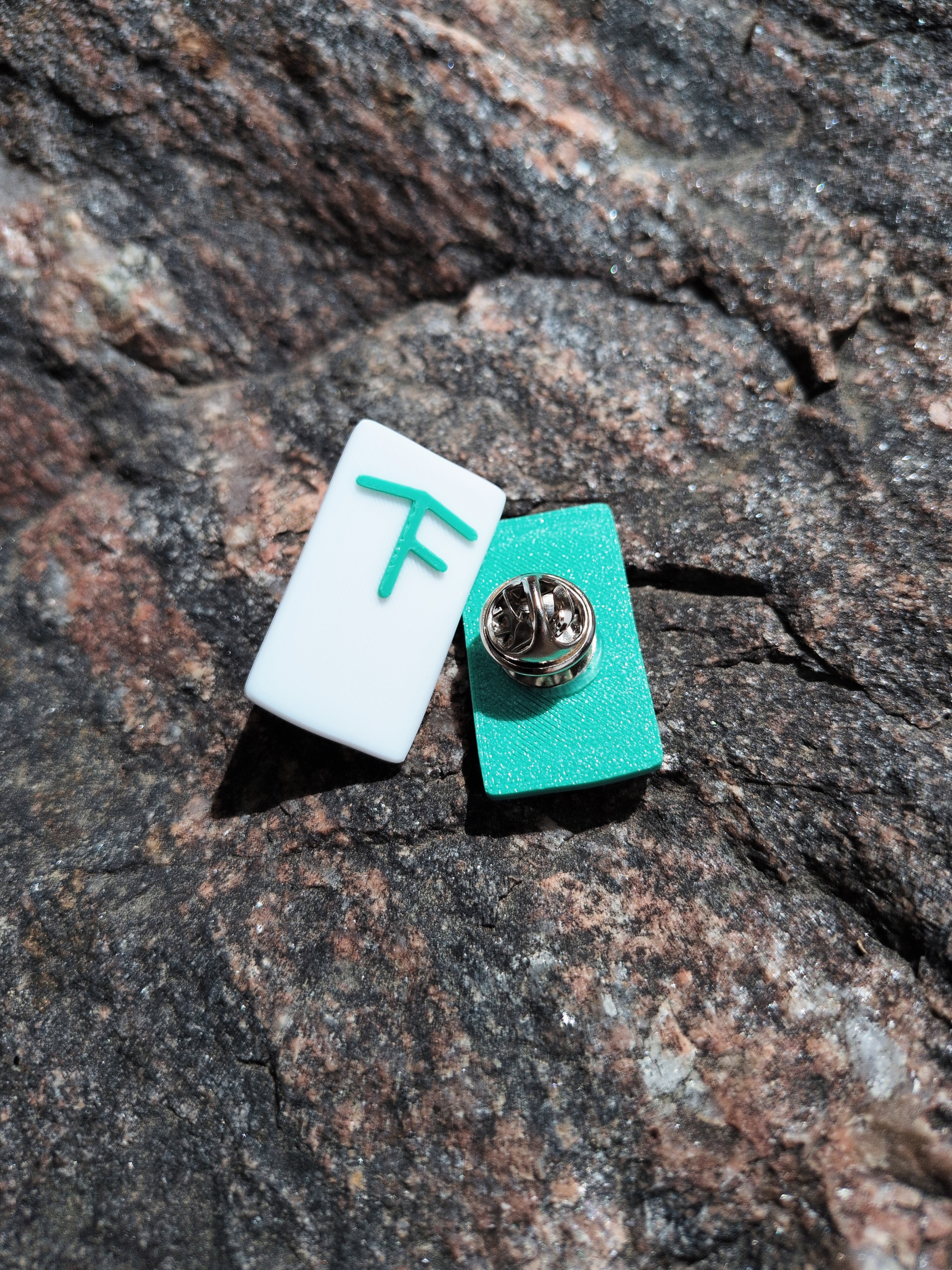 TrekFreely Blaze Pin showing the two colors and the butterfly clasp backing
